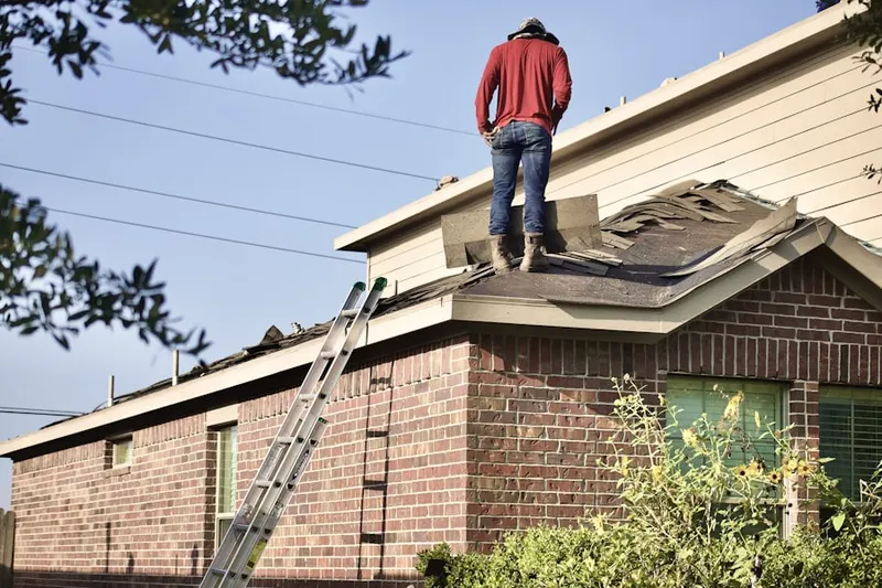 Professional roofer working on a residential roof in Malins